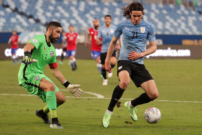 Claudio Bravo, arquero de Chile, trata de obstaculizar una acción de Edinson Cavani, delantero uruguayo.