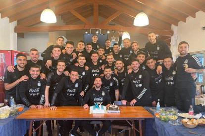 Lionel Messi con una torta y sus compañeros de la selección argentina.