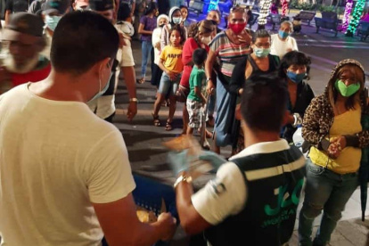 Jóvenes profesionales reparten los víveres a las personas que habitan en la calle.