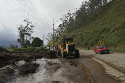 Maquinaria pesada realiza la limpieza de una vía afectada por deslaves.