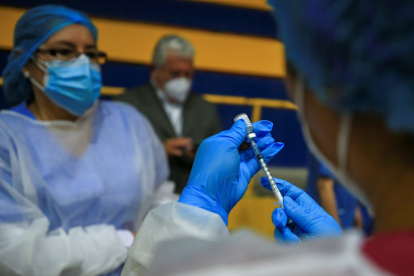 Personal de salud prepara una dosis de la vacuna contra la covid-19 en la Universidad Salesiana, en Quito.