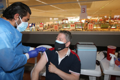 Un colaborador de La Favorita recibe la vacuna en uno de los locales de Supermaxi, dentro del plan pilto de vacunación en las empresas.