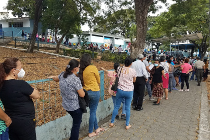 Decenas de personas forman una larga columna para recibir la vacuna en la Academia Naval Illinngworth,en el norte de Guayaquil, el jueves 8 de julio.