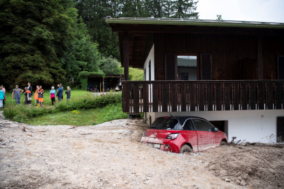 Un coche aparece semienterrado por las inundaciones en Schoenau am Koenigssee, Alemania.