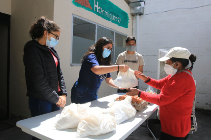 Intercambio. Alegría Parreño, Paula Herrera y Diego Yépez entregan una bolsa con alimentos a una beneficiaria de la fundación El Hormiguero.