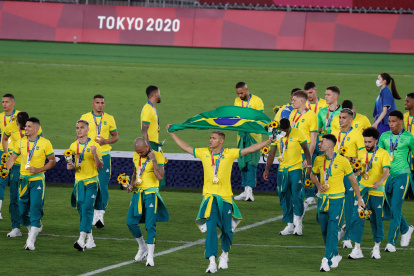 Los jugadores de Brasil se pasean por la cancha con la medalla de oro conseguida en la final del fútbol masculino.