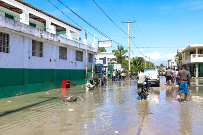 Grupos de personas transitan por una calle inundada tras un seísmo de 7,2 grados hoy, en Los Cayos (Haití).