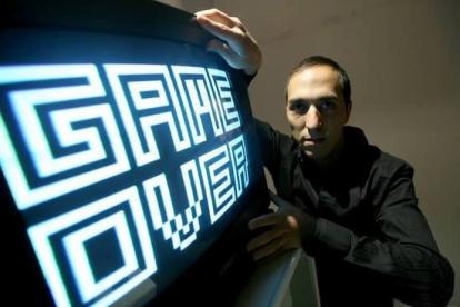 Fotografía cedida por el artista Yucef Merhi en la que aparece mientras posa junto a una de sus obras.