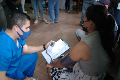 La venezolana Jéssica Castillo es valorada por un médico antes de aplicarle la vacuna.