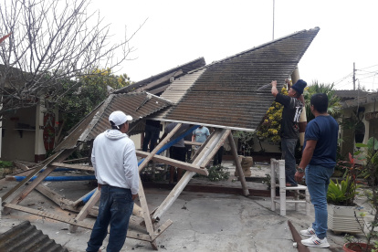 Un grupo de habitantes de Valdivia recogen los escombros del techo que se cayó en el museo del lugar.
