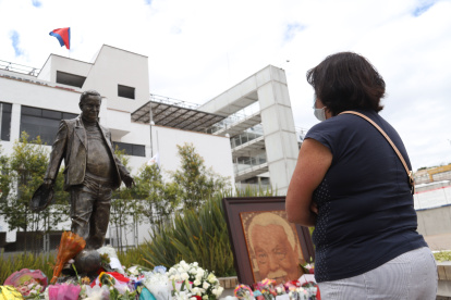 Una fanática de Liga de Quito frente a la estatua de Rodrigo Paz, exdirigente de Liga de Quito.
