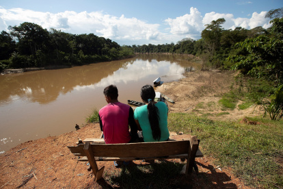 En junio de 2020, una pareja de indígenas del pueblo de Mayuruna cruiserinho, sentados en un banco a orillas del río Javari en Palmeiras do Javari, en la frontera con Perú. Brasil, la principal reserva hídrica del mundo, perdió más de tres millones de hectáreas en áreas cubiertas de agua dulce en 30 años.