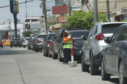 Los cuidadores de carros ponen palos, llantas y otros objetos para separar los espacios para el estacionamiento de personas que no habitan en la ciudadela Vernaza Norte.