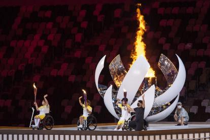 Three athletes light the fire during the opening ceremony during the opening ceremony of the 2020 Tokyo Summer Paralympics Games.