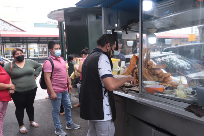 Alexander Intriago, co-dueño de Sánduches Don Lucho, faena diariamente 3 piernas de cerdo horneado a leña.