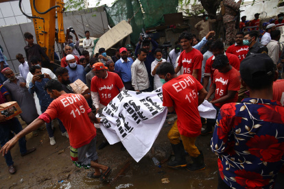 Rescatistas cuando sacan uno de los cuerpos calcinados. EFE/ SHAHZAIB AKBER