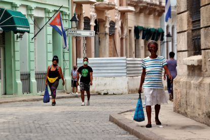 Varias personas con tapabocas caminan por una calle, en La Habana (Cuba).
