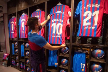 Un empleado de la Barça Store Camp Nou coloca la nueva camiseta del delantero del Barcelona, Ansu Fati, que se convierte en el heredero del dorsal 10 de Leo Messi