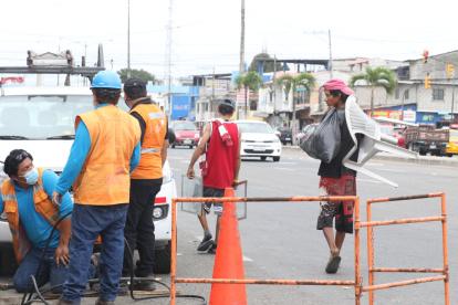 Labor. Los técnicos de CNT reemplazan los cables que se han robado en la avenida Juan Péndola, al sur de la urbe, mientras pasan dos recicladores.