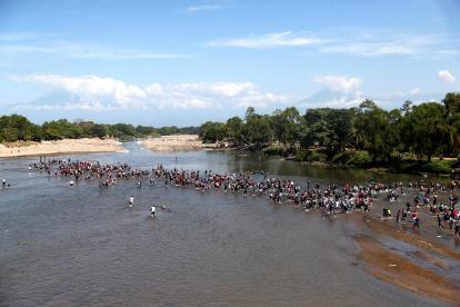 Referencial. Cientos de migrantes centroamericanos, en su mayoría hondureños, cruzan el río Suchíate que divide México y Guatemala este lunes, desde la ciudad de Tecún Umán (Guatemala).