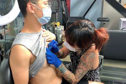 La tatuadora china Xie Tingyin trabajando en su estudio de Pekín. EFE / Jesús Centeno