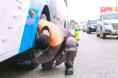 Un técnico de la ATM realiza revisa las llantes de un bus urbano de Guayaquil en un control de la ATM.