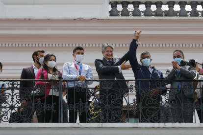 El presidente Lasso, con Carapaz a su derecha, levantó la mano también del padre del ciclista, quien lo acompañó al balcón del palacio de Carondelet.
