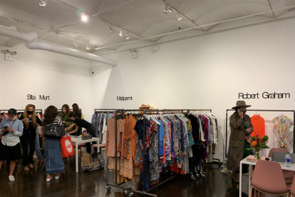 Varias personas miran los diferentes diseños de las marcas participantes en la feria FashionLab Market hoy viernes en Nueva York.