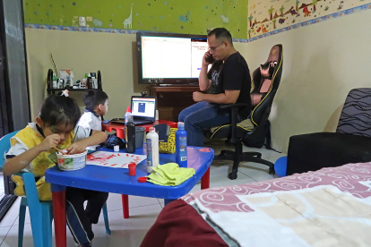 Washington Sánchez ayuda a sus dos hijos, que estudian en la Unidad Educativa Mariscal Sucre, en las clases virtuales en casa, mientras él labora en la modalidad de teletrabajo.