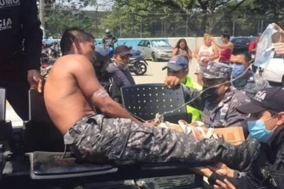 Un agente de la Policía herido es retirado del sector en ambulancia.