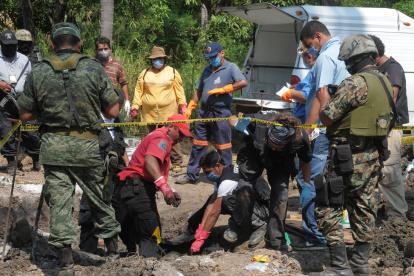 Fotografía de archivo en la que peritos forenses trabajan en una fosa clandestina de la cual ocho cadáveres fueron rescatados en México.