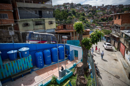 En la fotografía se puede apreciar tanques y filtros de agua de lluvia en la entrada de una escuela.