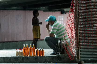 Mientras un hombre vende miel a orillas del paso peatonal de la avenida 25 de Julio, en el sur de la ciudad, otro vive en la indigencia. Apenas un metro separa sus realidades. Ambos, a su manera, buscan obtener unos dólares para sobrevivir.