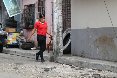 Obstáculo. Una persona camina en la vía por donde van los carros porque el poste ocupa la estrecha acera de la calle Mercedes Arzube y no hay espacio.