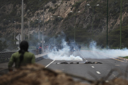 Policías antimotines se presentan en una vía bloqueada por manifestantes durante las movilizaciones contra las pretendidas reformas del Gobierno y en demanda de la congelación de los precios de los combustibles, hoy, en el acceso norte de Quito (Ecuador).