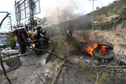 Manifestantes bloquean una vía durante las movilizaciones contra las pretendidas reformas del Gobierno y en demanda de la congelación de los precios de los combustibles, hoy, en el acceso norte de Quito (Ecuador).