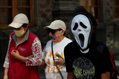 Un hombre con una mascara de la película "Scream" camina en una calle del Centro Histórico, el 26 de octubre de 2021, en la Ciudad de México (México).