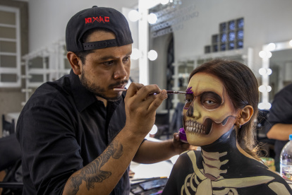 El artista del make-up Martín SBK maquilla a una modelo como Calacatrina, una combinación entre una calavera de rasgos tétricos y la Catrina, tradicional mujer esquelética del Día de Muertos mexicano. Foto: Jair Cabrera / DPA