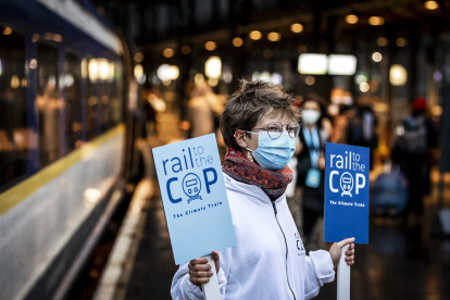 Pasajeros en Ámsterdam toman el llamado "tren climático" con destino a Londres para luego tomar otro transporte hasta Glasgow, sede del evento.