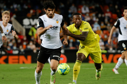 VALENCIA, 30/10/2021.- El delantero portugués del Valencia Gonçalo Guedes (i) lucha con el ecuatoriano Pervis Estupiñán, del Villarreal, durante el partido de la jornada 12 de LaLiga que se disputa hoy sábado en el estadio de Mestalla, en Valencia. EFE/Juan Carlos Cárdenas