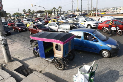 Hora pico. Una tricimoto se desplaza en contravía en este tramo, donde además los vehículos no guardan la debida distancia ni entre ellos.