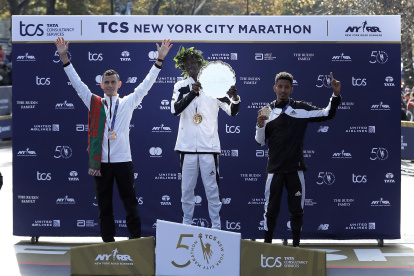 El ganador del maratón de Nueva York, el keniano Albert Korir (c), el subcampeón, Mohamed El Aaraby (i), y el tercer lugar, Eyob Faniel, festejan durante la premiación de la carrera.