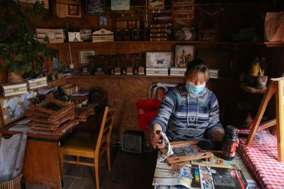 Atractivo. La artesana Micaela Kramer trabaja en una pieza dentro del antiguo vagón de tren que sirve de taller en su pueblo.