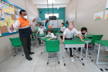 Los estudiantes del Liceo Panamericano arrastran sus pupitres hasta la puerta para formar una barricada, durante un simulacro de atentado en el plantel.