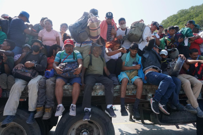 Migrantes centroamericanos abordan camiones, para continuar con su caravana hacia EEUU, este viernes en la comunidad de Santiago Niltepec, en el estado de Oaxaca (México).