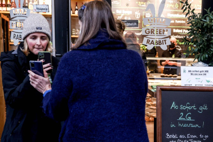 Unas clientas muestran su pasaporte de vacunación para acceder a un restaurante en Berlín.
