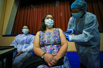Fotografía de archivo en la que se registró a una mujer al ser vacunada contra la covid-19, en la Universidad Salesiana, en Quito (Ecuador).