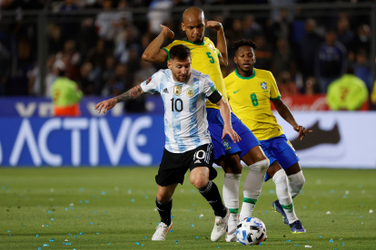 Lionel Messi (i) de Argentina disputa el balón con Fabinho de Brasil en un partido de las eliminatorias sudamericanas para el Mundial de Qatar 2022.