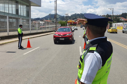 Agentes de tránsito dirigen y controlan la circulación en una de las calles de Cuenca.