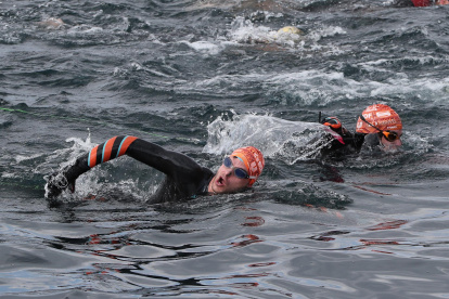 Los franceses Théo Curin (d), nadador y medallista paralímpico, y Matthieu Witvoet, quien recorrió una veintena de países en bicicleta en 2017 descubriendo soluciones locales a los residuos plásticos, halan, el 10 de noviembre de 2021, el bote en el que se encuentra su compatriota Malia Metella.